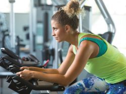 Woman riding stationary bike in fitness center